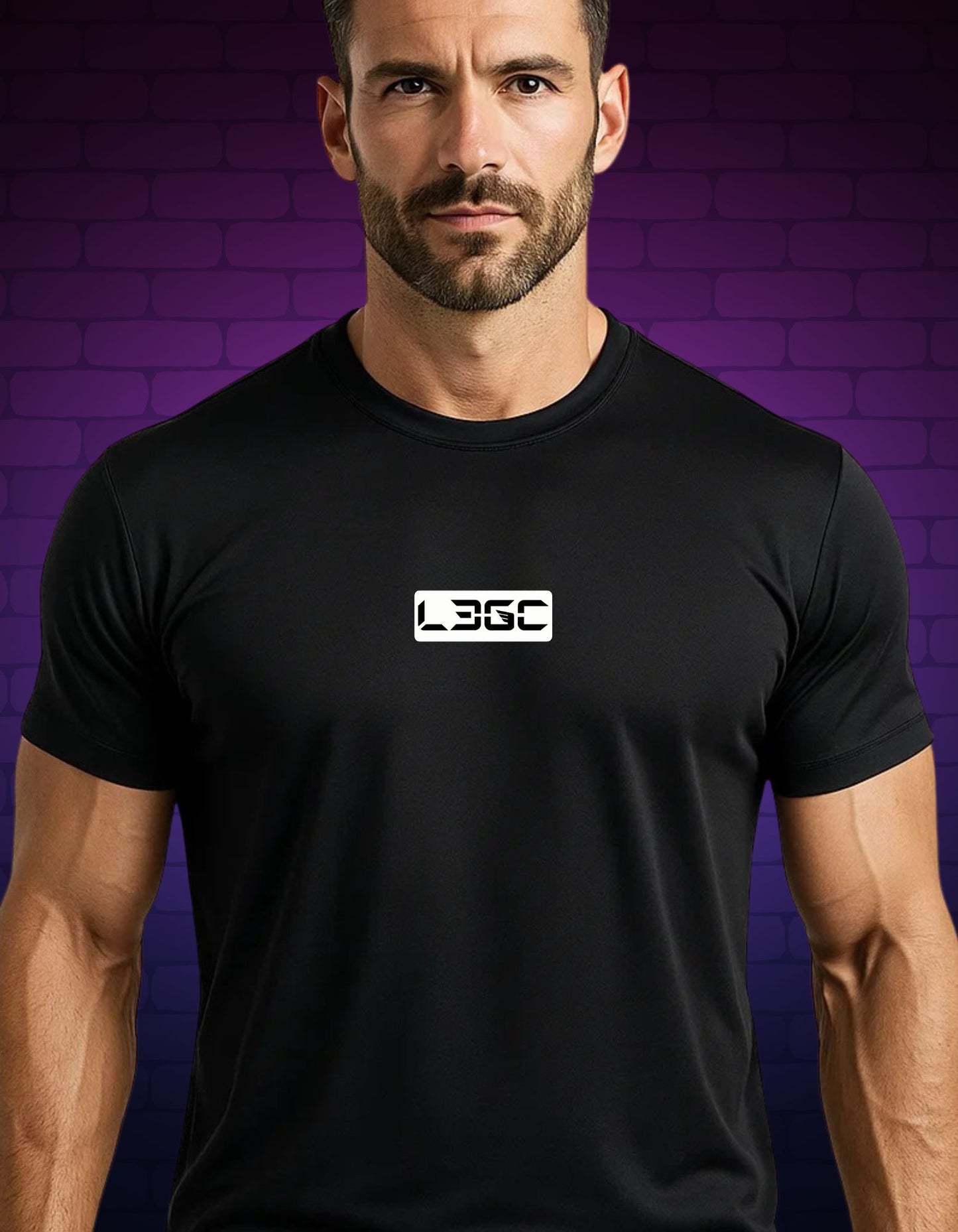 Man wearing a black t-shirt with a logo against a purple brick wall