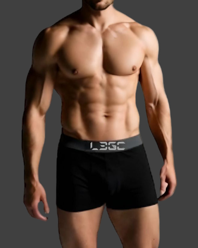 Man wearing black boxer briefs with a visible brand logo on a white background