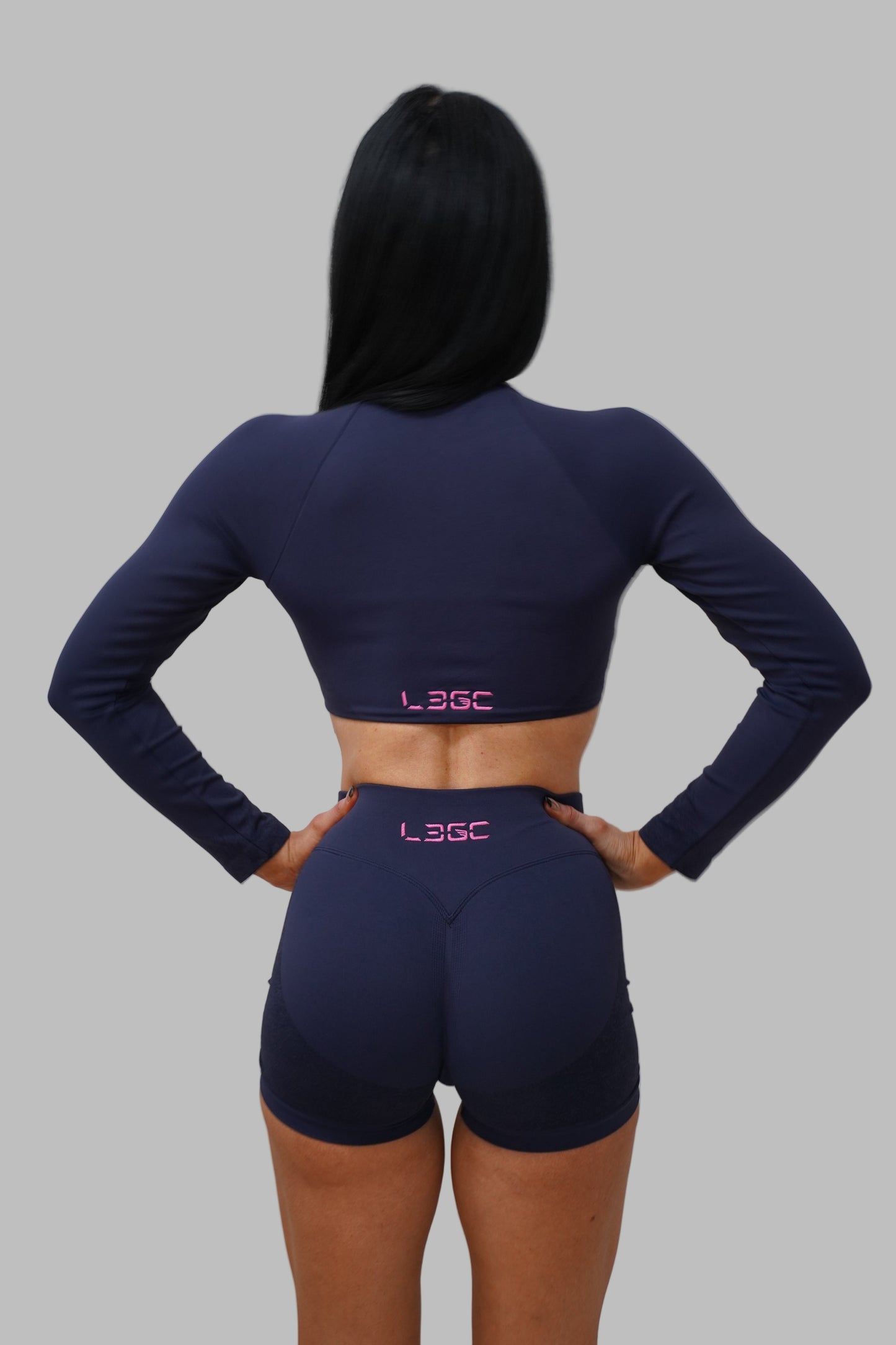 woman wearing navy blue athletic outfit with 'LEGC' branding.
