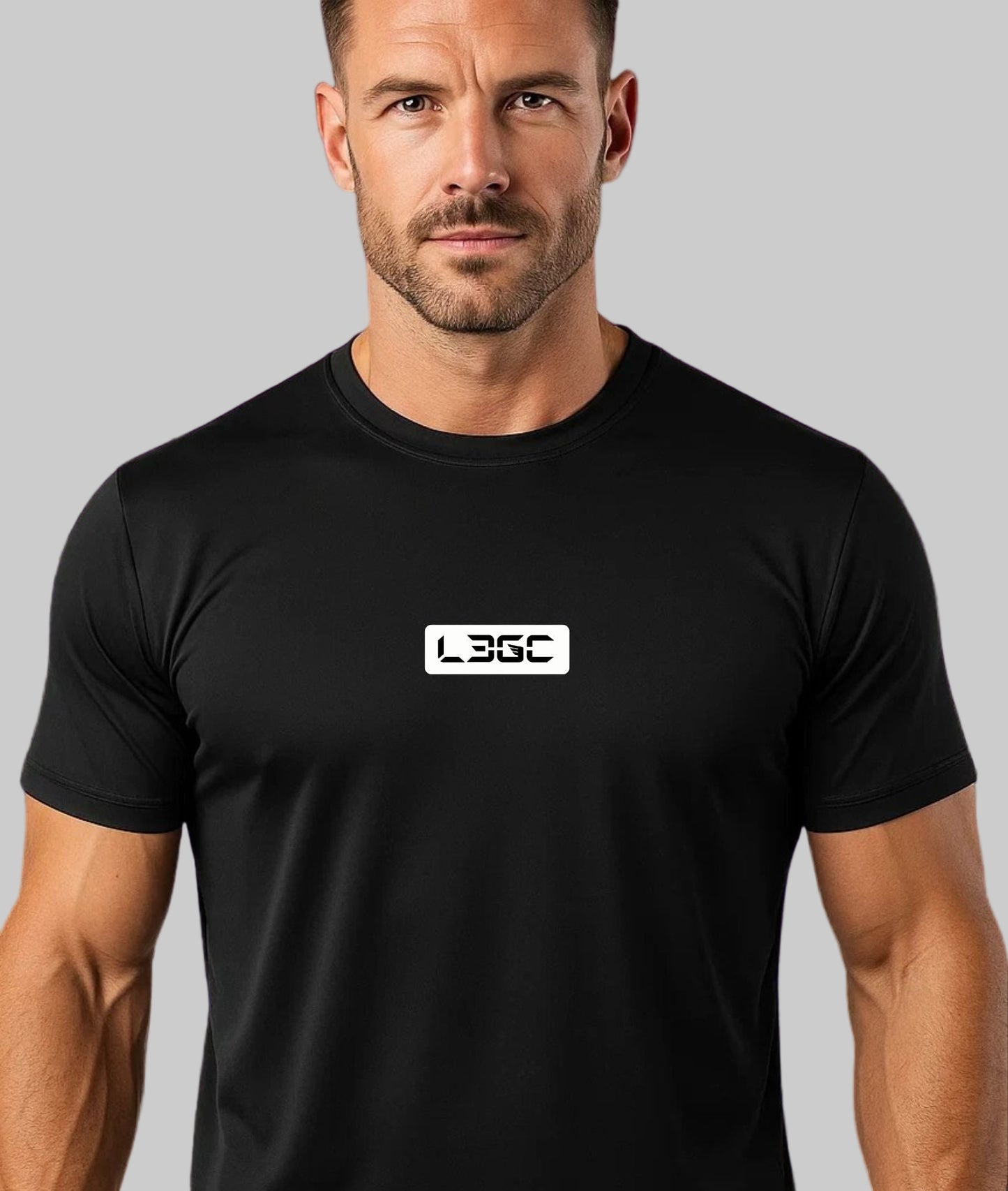 Man wearing a black t-shirt with a logo against a purple brick wall