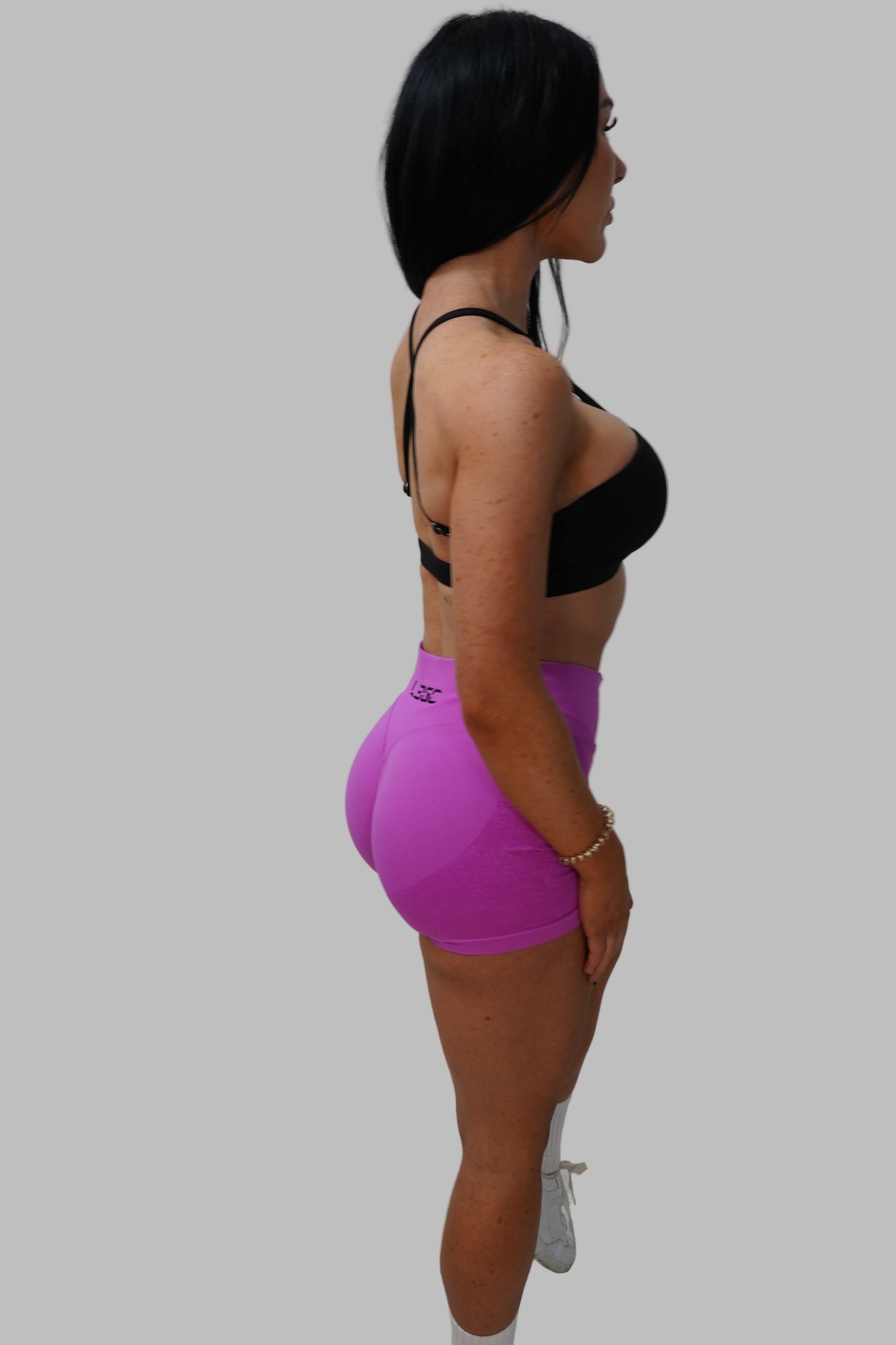 Person wearing a pink short and black crop top.