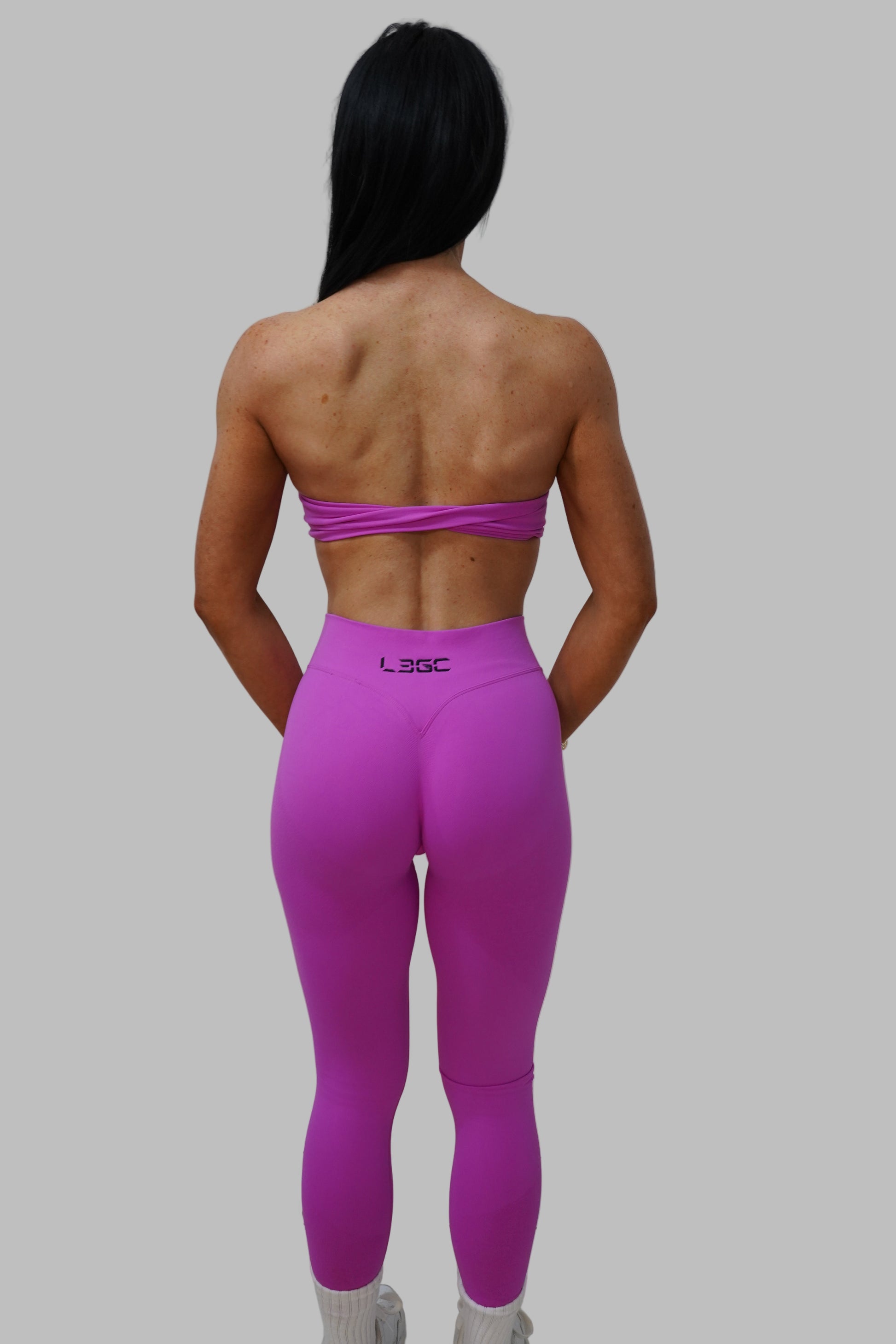 woman wearing bright pink leggings and a sports bra.