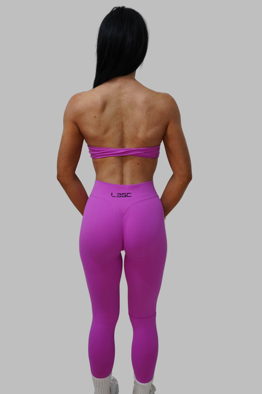 woman wearing bright pink leggings and a sports bra.