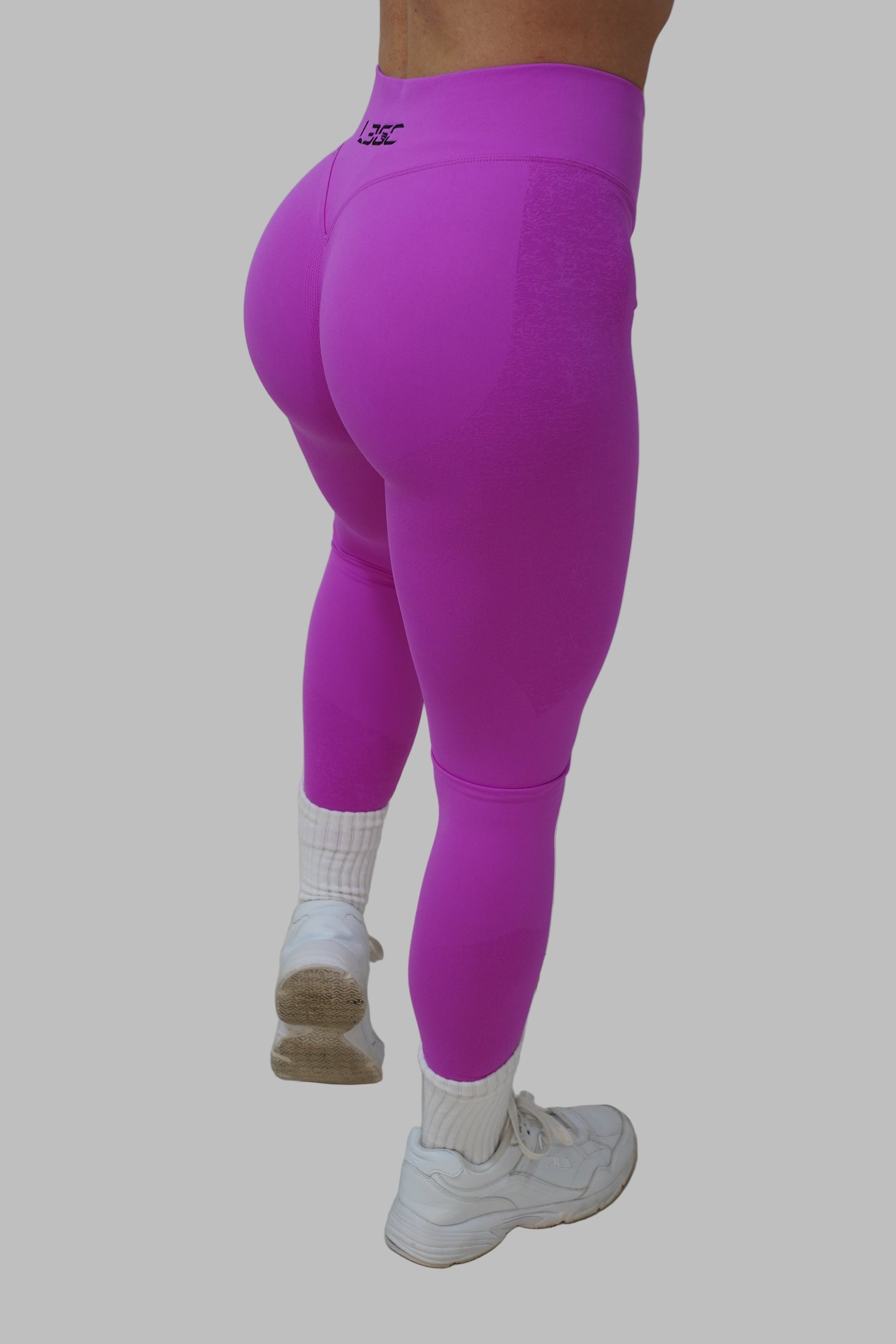 woman wearing pink leggings and white sneakers.