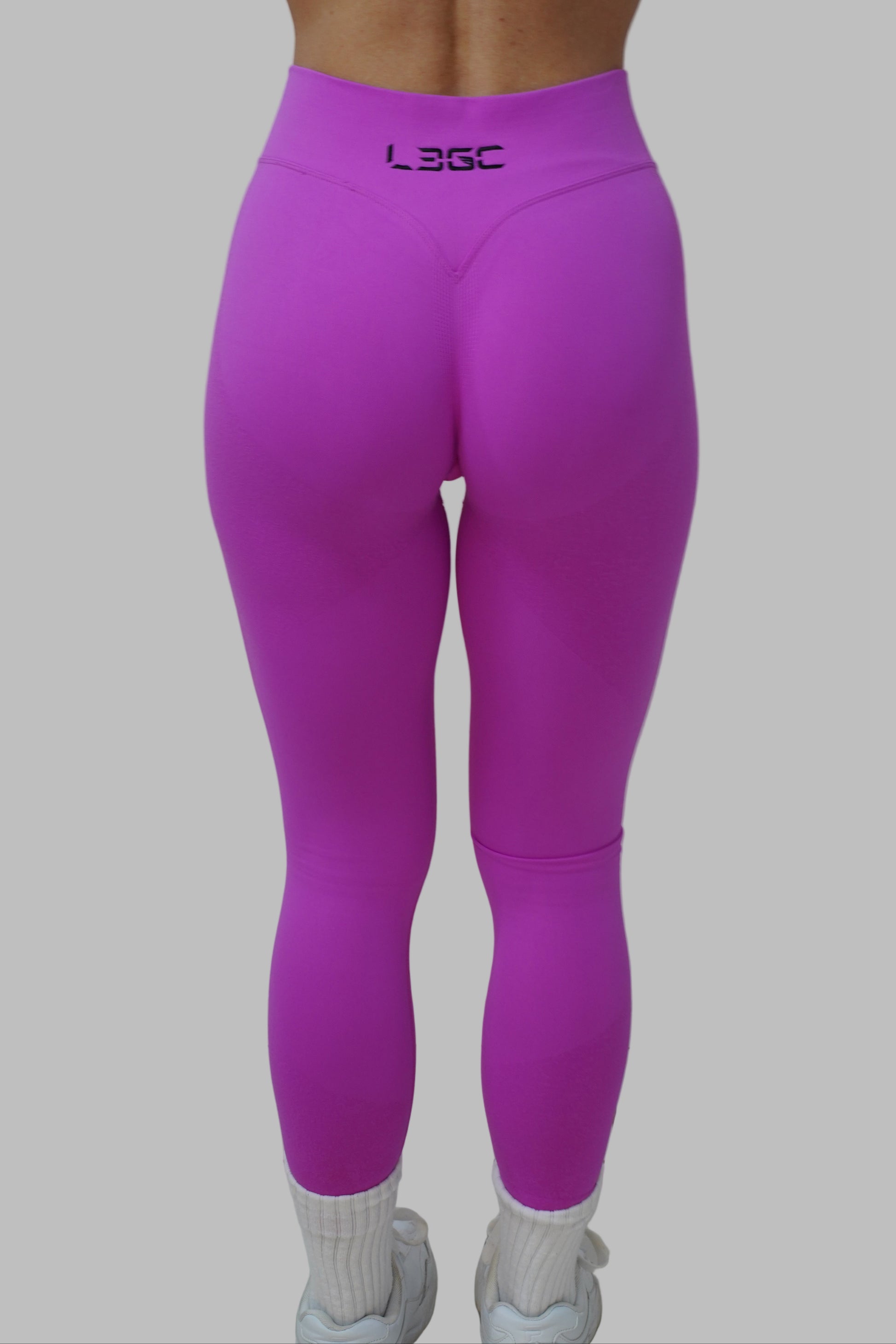 woman wearing bright pink leggings with LEGC brand logo.